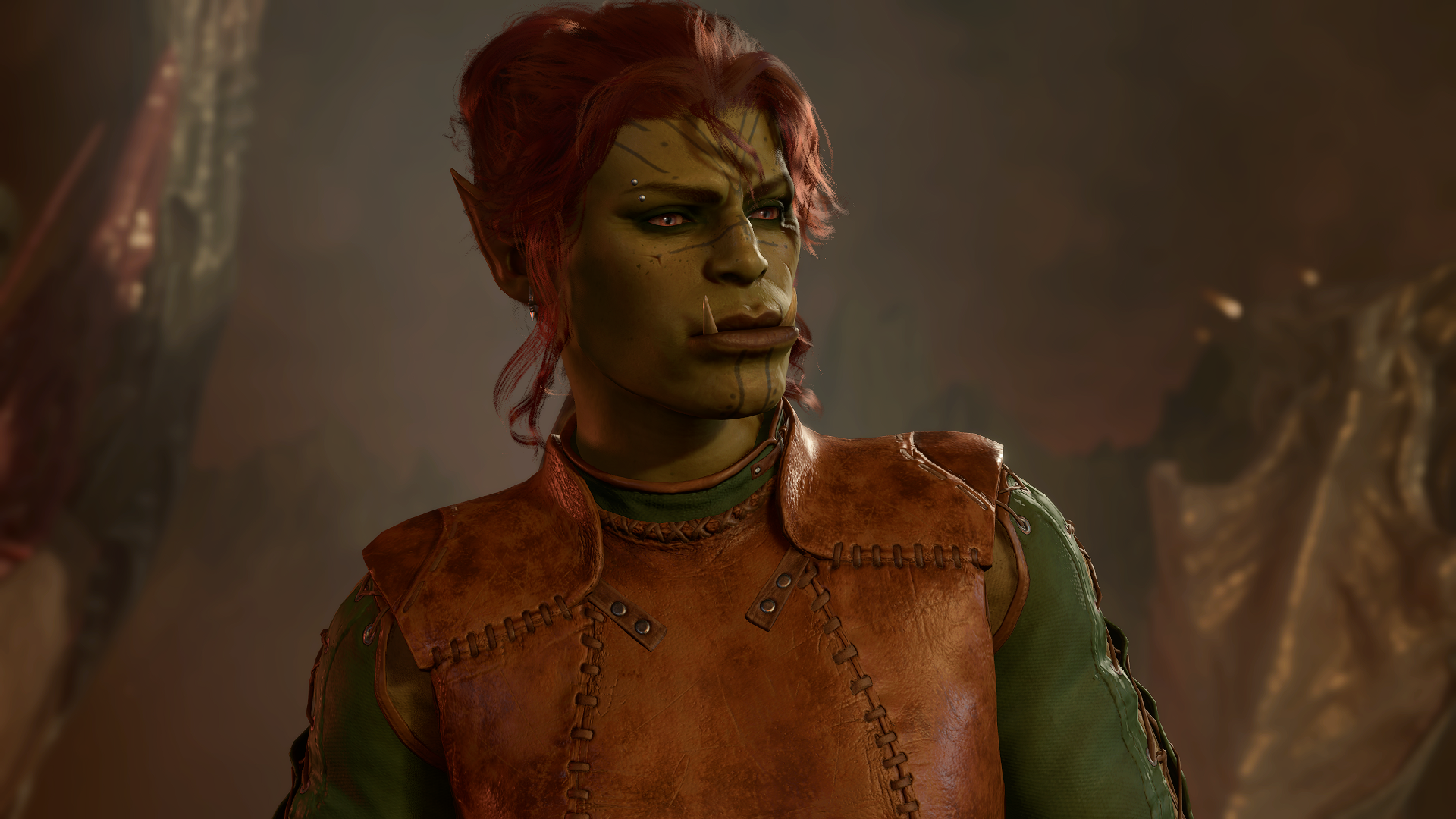 Gi'ada, a tall half-orc woman with light green skin and protruding tusks. Her hair is auburn and tied in a messy but practical bun. She's very pretty.